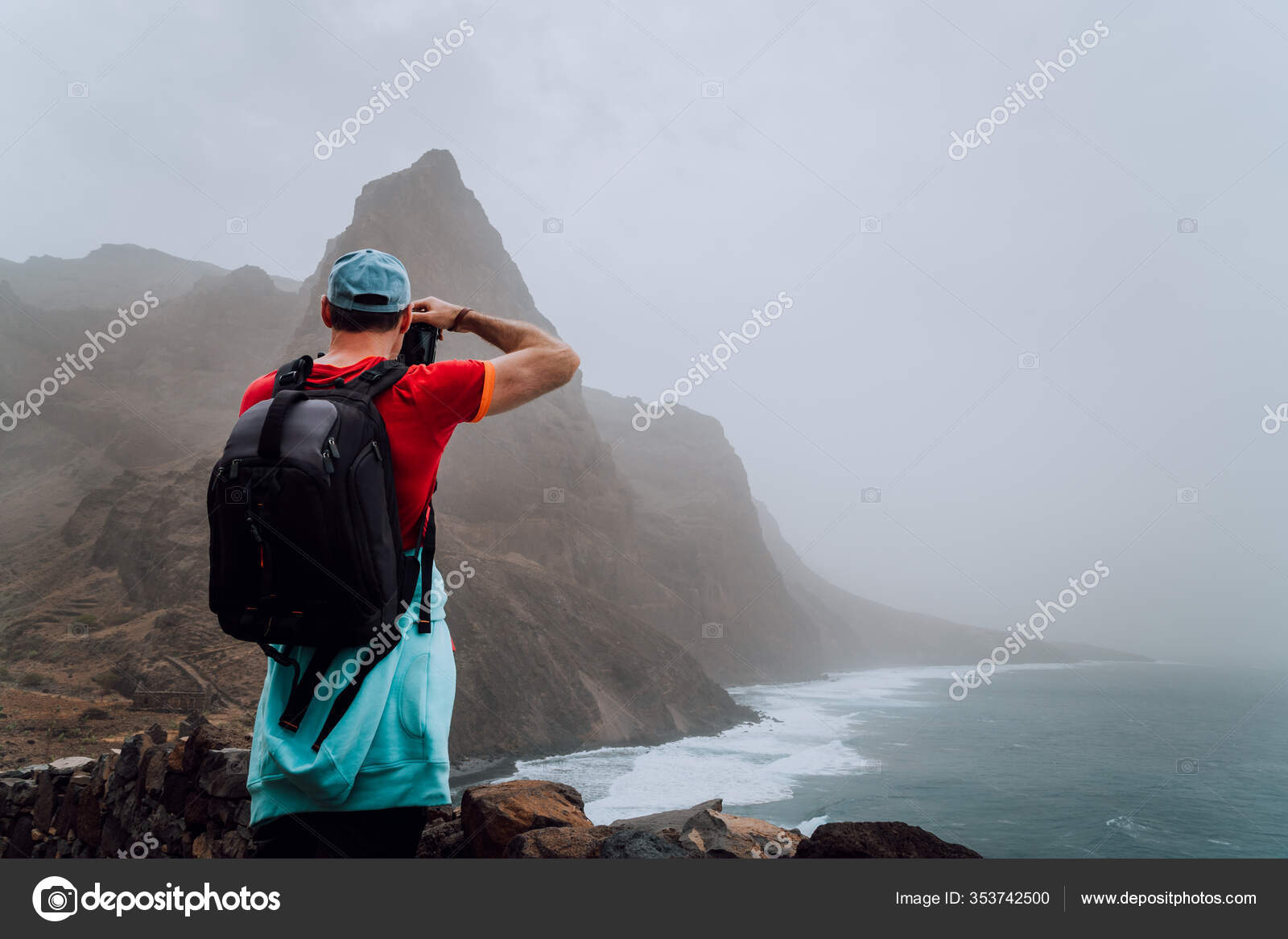 Turista masculino con mochila en la pintoresca carretera costera