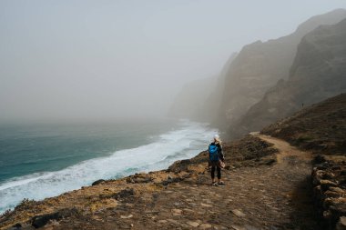 Santo Antao, Cape Verde - Cruzinha da Garca 'dan Ponta do Sol' a yürüyüş yapan kadın yürüyüşçü. Dengesiz Atlantik Okyanusu kıyısı