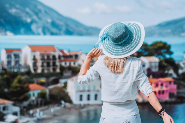 As mulheres turistas admiram a cidade de Assos colorida na ilha de Kefalonia, Grécia. Sommer férias férias vintage vibe cores — Fotografia de Stock