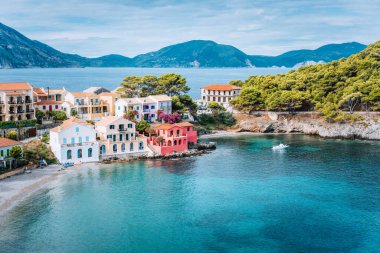 Yunanistan, Kefalonia 'da tatil. Assos köyünün önündeki mavi körfez. Mavi turkuaz renkli, şeffaf koy lagününün yanındaki renkli evlere güzel bir manzara.