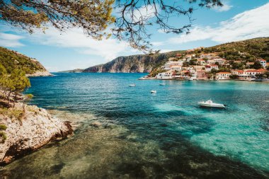 Yunanistan yaz tatili. Kefalonia adasındaki güzel Assos kasabası. Arka planda tekneleri ve köyü olan körfez
