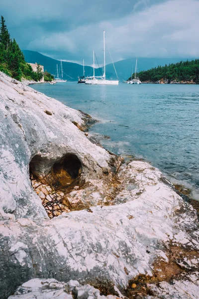 Пляж у небольшого городка Фискардо в Кефалонии, Ионические острова, Греция. Морской залив с частной белой яхтой в лагуне — стоковое фото