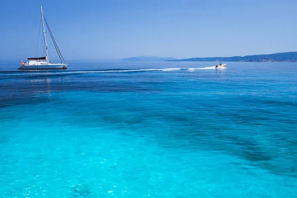 Vacances de vacances. Lagune bleu azur avec vagues calmes et voilier catamaran à voile dérivant bateau avec littoral en arrière-plan — Photo