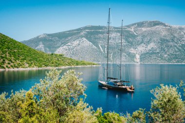 Yunanistan 'da yaz tatili. Güzel deniz gölünde demirli lüks siyah bir yat var. Ithaka Adası
