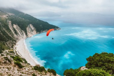 Yaz sezonu aktivitesi. Planör güzel Myrtos plajında uçuyor. Kefalonia Adası, Yunanistan. İnanılmaz su renkleri ve dağ kıyıları