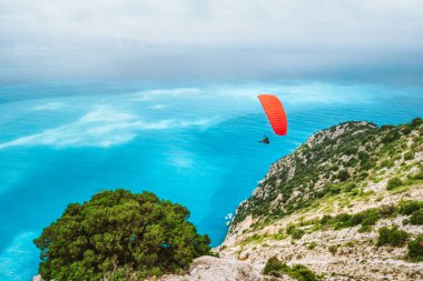 Paraglider Myrtos sahilinde uçuyor. Kefalonia Adası, Yunanistan. Eğlence hobisi etkinliği