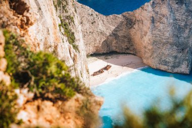 Naavagio sahilindeki ünlü gemi enkazı. Mavi deniz koyunun etrafı dev beyaz kireçtaşı kayalıklarla çevrili. Yunanistan 'ın Zakynthos adasında ünlü bir yer