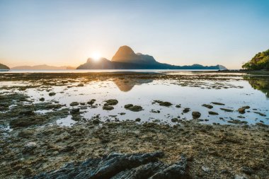Gün batımında El Nido sahili alçak gelgitte gün batımıyla aydınlanır. Resimli doğa manzarası. Palawan, Filipinler