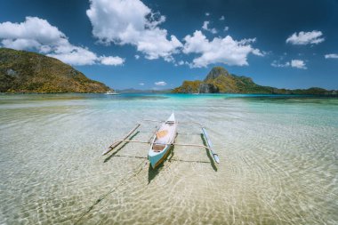 El Nido Körfezi. Palawan Adası, Filipinler. Öğle vakti sığ su gölünde yalnız filipinli balıkçı teknesi. Egzotik seyahat.