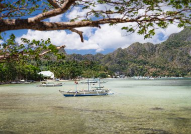 El Nido körfezi alçak gelgitte. Bangka, dalgaların çekildiği sığ sularda balık tutuyor. Palawan, Filipinler