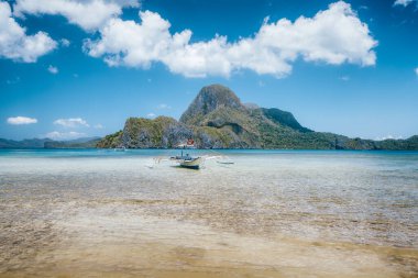 El Nido Körfezi. Palawan Adası, Filipinler. Geleneksel Filipinli balıkçı teknesi sığ mavi gölde. Rüya gibi tatil konsepti.