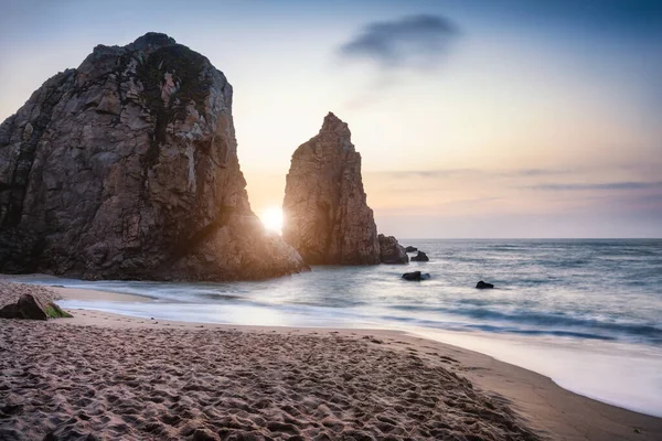 Sonnenuntergang am Ursa Beach Sea Stack, Portugal. Atlantik Schäumende Wellen wälzen sich zum Sandstrand. Urlaubslandschaft — Stockfoto