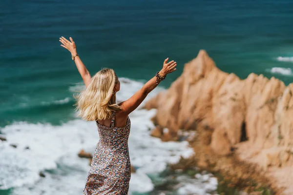 Mulheres bonitas levantando as mãos desfrutando de brisa oceânica na impressionante Praia da Ursa, na luz da manhã. Paisagem surreal de Sintra, Portugal. Oceano Atlântico paisagem litoral — Fotografia de Stock