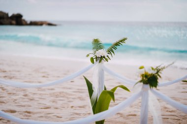 La Digue, Seyşeller. Düğün dekorasyonunun kapanışı. Tropikal bir kumsalda beyaz çiçekler.