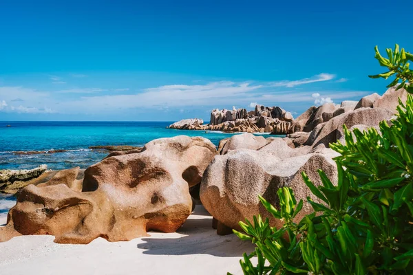 La Digue, Seychelles állam. Gyönyörű távoli trópusi strand zöld lombozattal, egyedi gránit sziklákkal és kék égbolttal — Stock Fotó