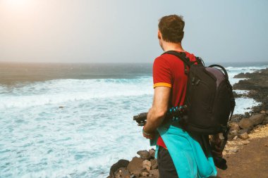 Erkekler sırt çantasıyla Atlantik Okyanusu 'nun manzaralı sahillerinde fotoğraf çekerler. Cruzinha ve Ponta do Sol 'dan yürüyüş. Santo Antao. Cape Verde