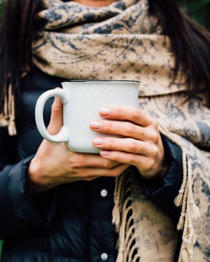 bir fincan sıcak çay tutan eller