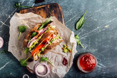 Guacamole, domates, roka ve pastırma sandviç