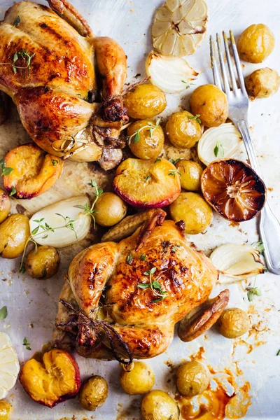 Two roasted chicken with potatoes. top view