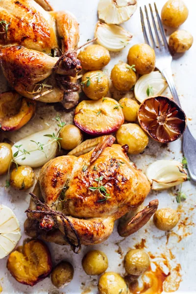 Two roasted chicken with potatoes. top view