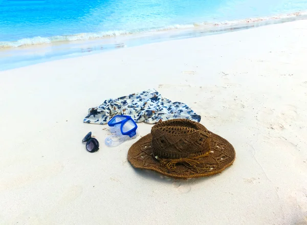 Strohhut, Maske. Sonnenbrille und Kleid am tropischen Strand — Stockfoto