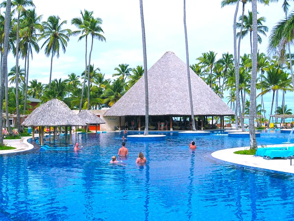Punta Cana, República Dominicana - 03 de fevereiro de 2013: Turistas comuns descansando em Barcelo Bavaro Beach hotel com piscina sob as palmas das mãos — Fotografia de Stock