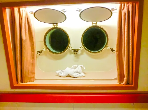 Postava ručník proti dvě okna v kabině — Stock fotografie