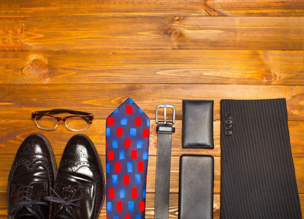 The elegant male set: mens shoes, leather belt, on the wooden background. — Stock Photo, Image