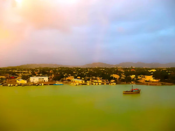Small yellow boats and many colorful buildings on the coast of Martinique. Image blurred in postproduction