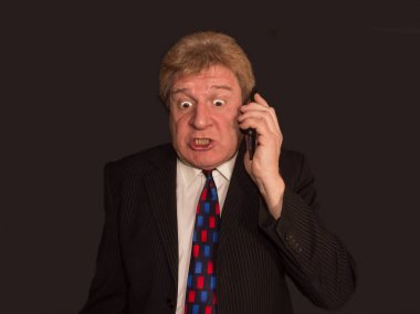 Şok haber. Cep telefonu ile takım elbiseli şaşırmış olgun adam