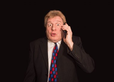 Şok haber. Cep telefonu ile takım elbiseli şaşırmış olgun adam