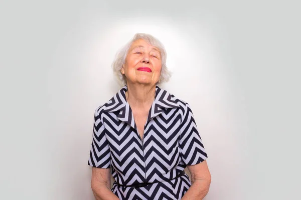 Retrato de una mujer mayor soñadora sentada con los ojos cerrados . — Foto de Stock