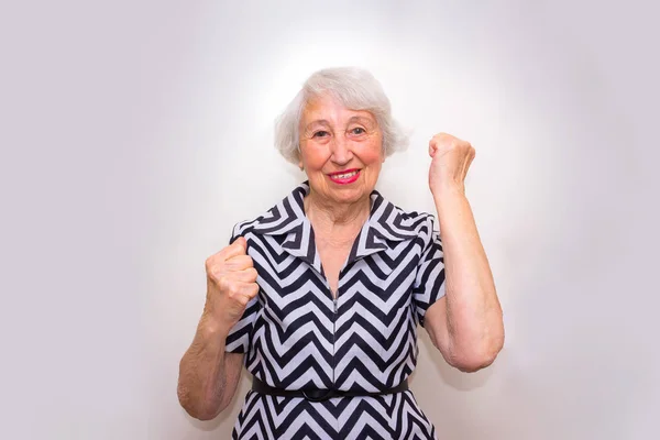 El retrato de una alegre mujer mayor haciendo gestos de victoria sobre el rosa — Foto de Stock