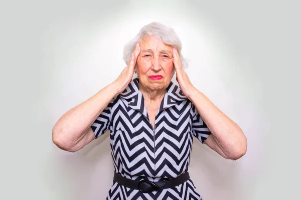 Старша жінка з головою в руках дивиться втомлений — стокове фото