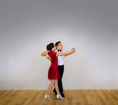 Genç erkek ve kız dans stüdyosu gri poz. Balo salonu dans kavramı