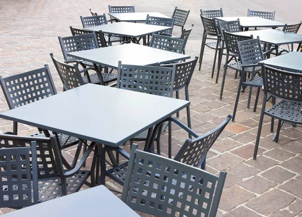 Boş masa ve sandalyeler kafe önünde