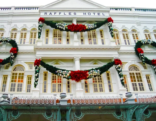 Singapure - 24 de diciembre de 2008: Las decoraciones navideñas en la fachada del Hotel Raffles en Singapur . — Foto de Stock