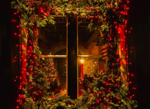 Weihnachtsbaum und Kamin durch ein Holzkabinenfenster gesehen — Stockfoto