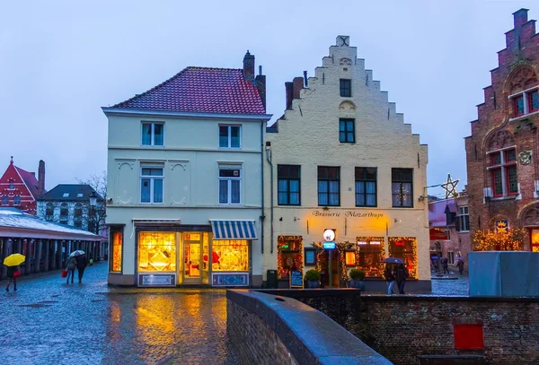 Bruggy, Belgie - 13 prosince 2017: Lidé u historických středověkých budov podél kanálu v Bruggách — Stock fotografie