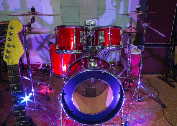 Modernes Schlagzeug auf der Bühne vorbereitet für das Spiel im strahlend blauen Licht — Stockfoto