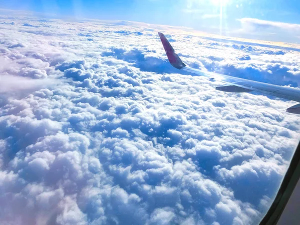 Vista da asa de um avião voando acima das nuvens. Nuvens e — Fotografia de Stock