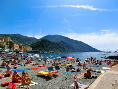Camogli, İtalya - 15 Eylül 2019: Güneşli yaz gününde insanlar Camogli plajında dinleniyor