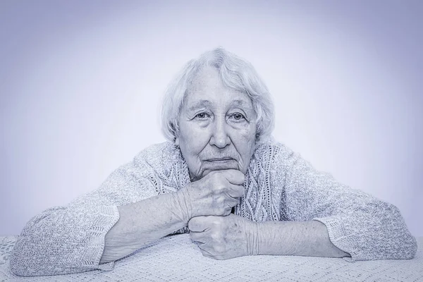 La triste donna dai capelli grigi anziana che sogna sul grigio — Foto Stock