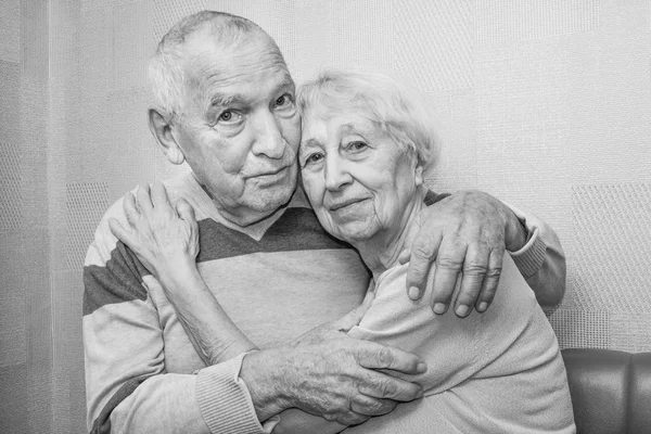 Счастливые любящие взрослые мужчина и женщина обнимаются, глядя в камеру. — стоковое фото