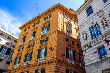 Şehrin eski bir bölgesindeki eski bir İtalyan binasının cephesi, panjurlu pencereler, Cenova, İtalya 'da eski bir bina..