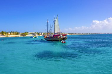Tourists snorkeling along the coastline and enjoy the tropical island of Aruba clipart