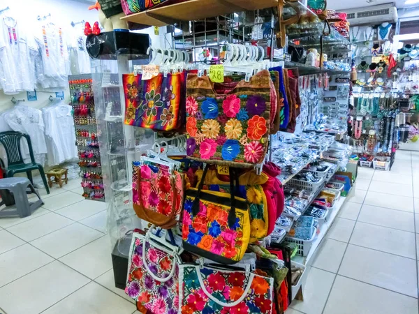 Etnik hediyelik eşyalar, beyzbol şapkaları, sokak pazarında asılı çeşitli desenli çantalar. — Stok fotoğraf