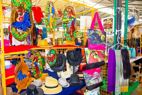 Puerto Limon, Kostaryka - 8 grudnia 2019: Pamiątki etniczne, czapki z daszkiem, torby o różnym wzorze wiszące na targu ulicznym — Zdjęcie stockowe