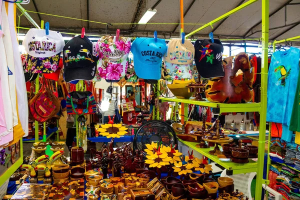 Puerto Limon, Kostarika - 8. prosince 2019: Etnické suvenýry, baseballové čepice, tašky s různým vzorem zavěšené na pouličním trhu — Stock fotografie