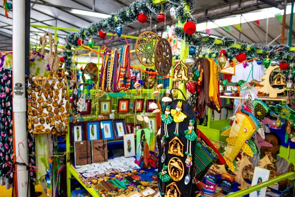 Puerto Limon, Kostaryka - 8 grudnia 2019: Pamiątki etniczne, czapki z daszkiem, torby o różnym wzorze wiszące na targu ulicznym — Zdjęcie stockowe